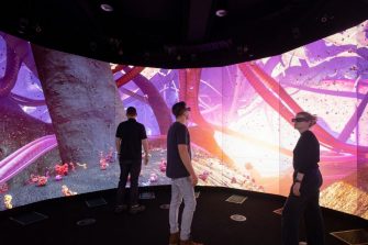 Three people walk through the animation at the UNSW 3DXLab. 